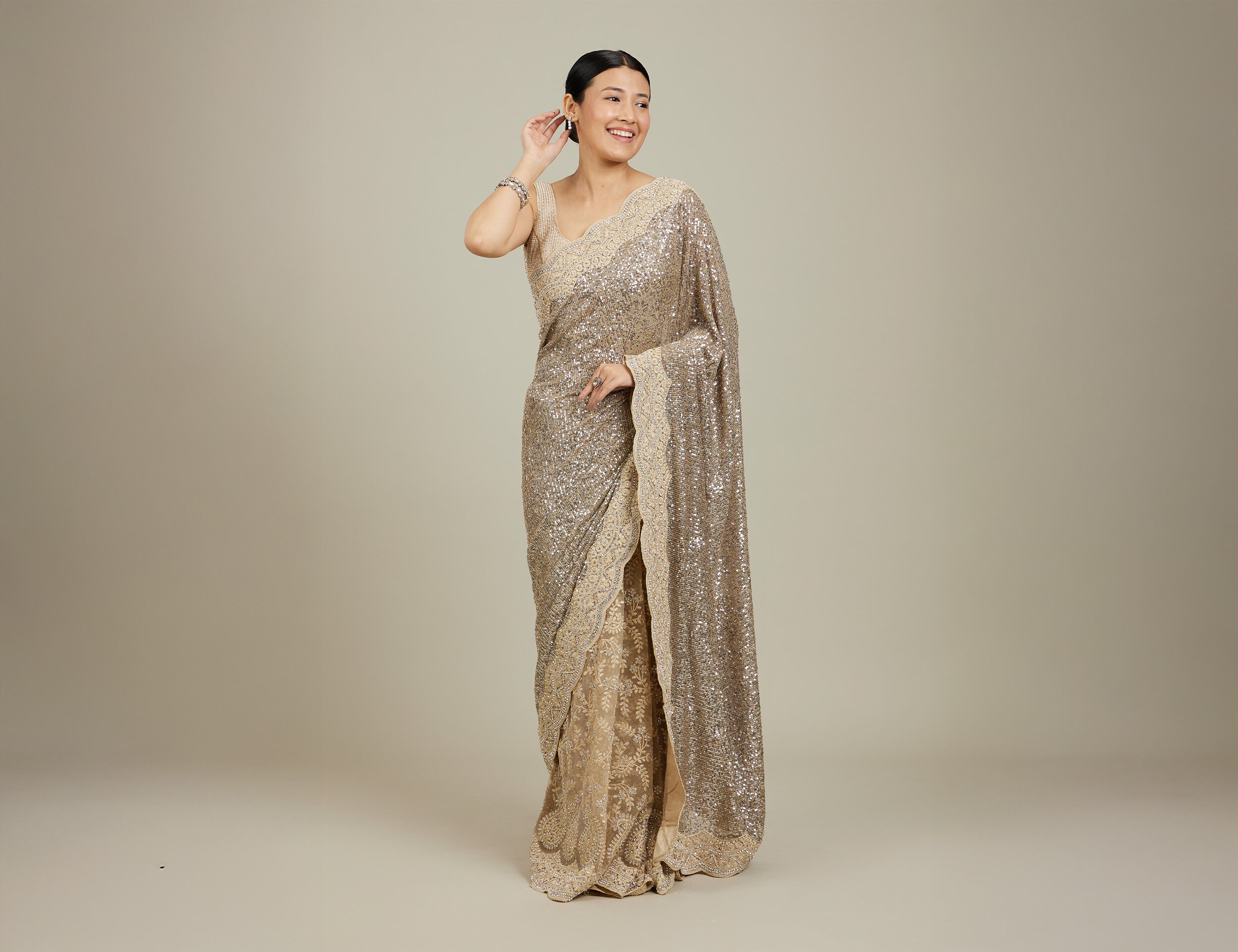 A pretty woman flaunting her silver colour net saree